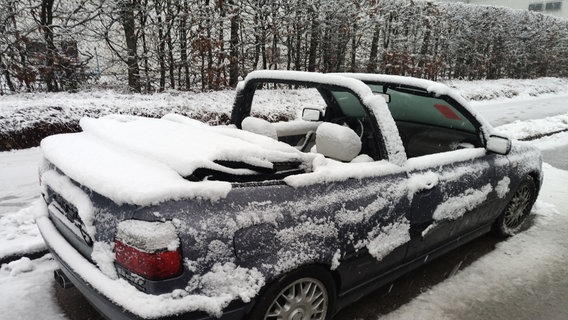 Ein Cabrio mit offenem Verdeck bei Schneefall in Stadthagen © NDR 