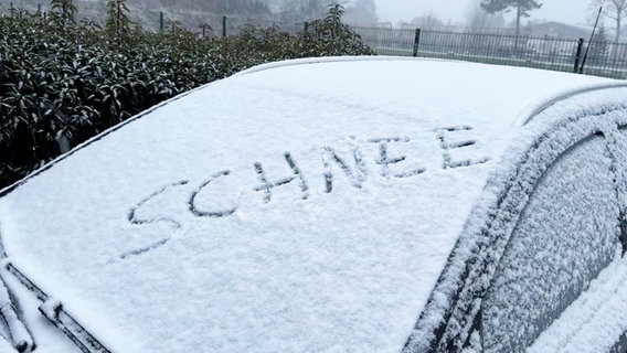 Auf der verschneiten Windschutzscheibe eines Autos steht "Schnee" geschrieben. © NonstopNews 