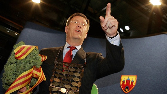 2005: Der neue Grünkohlkoenig der Stadt Oldenburg, der Ministerpräsident von Niedersachsen Christian Wulff (CDU), präsentiert das Zepter aus Grünkohl und die Königskette. © picture alliance / AP Photo | MARKUS SCHREIBER Foto: Markus Schreiber