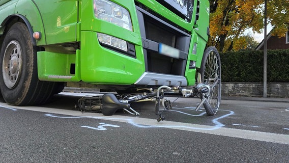 Ein Fahrrad liegt auf der B214 bei Ankum nach einem Unfall unter einem LKW. © Nord-West-Media TV 