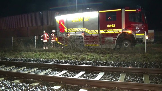 Hinter Bahngleisen steht ein Feuerwehrauto. © NordwestMedia 