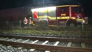 Hinter Bahngleisen steht ein Feuerwehrauto. © Nord-West-Media TV 