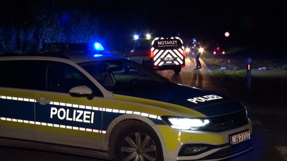 Nach einem Unfall in Bersenbrück stehen Fahrzeuge von einem Notarzt und der Polizei im Dunkeln an der Unfallstelle. © Nord-West-Media TV 