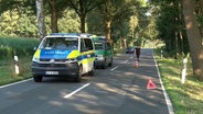 Eine Polizisten und Einsatzfahrzeuge an einer Unfallstelle in Bippen (Landkreis Osnabrück). Ein Mann ist bei dem Unfall schwer verletzt worden. © Nord-West-Media TV 