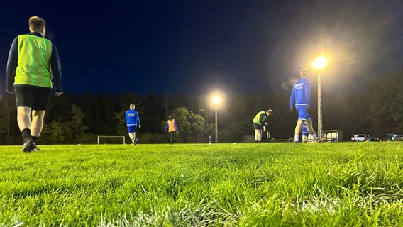 Auf einem beleuchteten Fußballplatz wird Fußball gespielt. © NDR Foto: Paul Hintzke