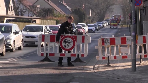 Nach dem Fund einer Weltkriegsbombe in Osnabrück sperrt ein Polizist eine Straße. © Nord-West-Mediat TV 