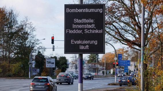 "Bombenräumung - Evakuierung läuft" steht auf einem Straßenschild. Wegen einem Bombenverdacht im Stadtteil Fledder müssen fast 14.000 Menschen ihre Häuser verlassen. © dpa Foto: Friso Gentsch