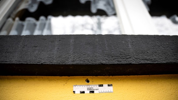 Einschusslöcher an einer Hauswand von der Spurensicherung markiert © Sina Schuldt/dpa Foto: Sina Schuldt/dpa