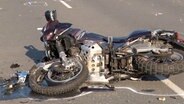 Ein Motorrad liegt nach einem Unfall auf einer Straße in Bramsche. © Nord-West-Media TV 