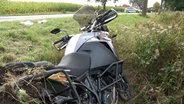 Ein Motorrad liegt nach einem Unfall neben einer Straße in Bramsche. © Nord-West-Media TV 