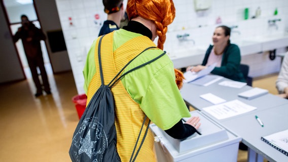 Eine als Pippi Langstrumpf verkleidete Wählerin wirft in einem Wahllokal in Damme (Landkreis Vechta) ihren Stimmzettel für die Bundestagswahl in eine Wahlurne. © Hauke-Christian Dittrich/dpa Foto: Hauke-Christian Dittrich/dpa