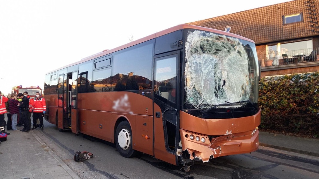Ein beschädigter Bus steht nach einem Unfall auf einer Straße.