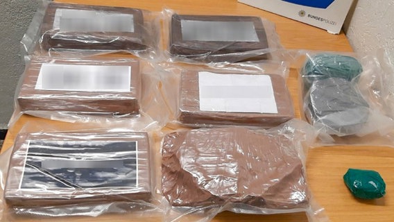 Tüten mit mehreren Kilogramm Kokain, dahinter ein Schild der Bundespolizeiinspektion Bad Bentheim © Bundespolizeiinspektion Bad Bentheim 