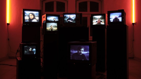 Mehrere alte, sehr kleine Fernseher stehen aufeinander. Auf den Bildschirmen sind einzelne Personen zu sehen. © Octavian Mot, Daniela Nedovescu, Mots Foto: Octavian Mot, Daniela Nedovescu, Mots