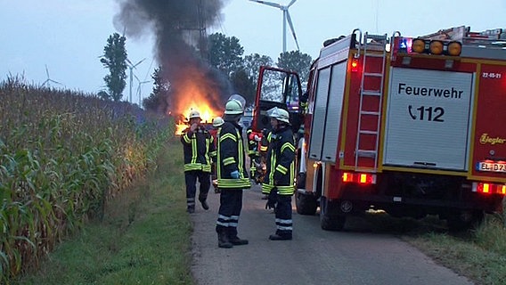 Feuerwehrleute stehen vor einem brennenden Ölfeld im emsländischen Osterbrock. © dpa-Bildfunk Foto: NWM-TV