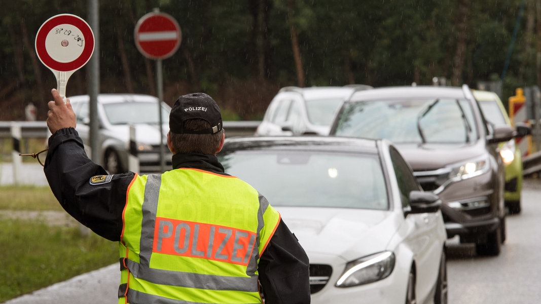 Ein Beamter der Bundespolizei leitet am 1. Juli 2017 den Einreiseverkehr aus den Niederlanden auf der A30 bei Bad Bentheim (Niedersachsen) zur Kontrolle über einen Parkplatz.