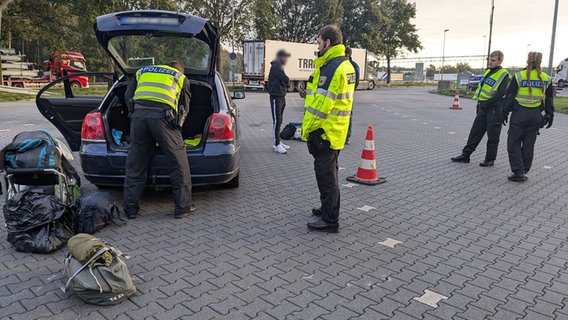 Polizeibeamte kontrollieren an einem niederländischen Grenzübergang einen Pkw. © NDR Foto: Claus Halstrup