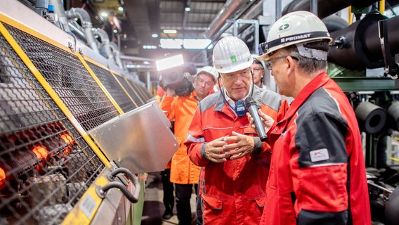 Robert Habeck (l, Bündnis 90/Die Grünen), Bundesminister für Wirtschaft und Klimaschutz, geht gemeinsam mit Volker Glane, Leiter Technologie Wärmebehandlung und Prüftechnik, durch das Stahlwerk der Georgsmarienhütte GmbH. © dpa-Bildfunk Foto: Hauke-Christian Dittrich