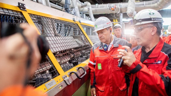 Robert Habeck (l, Bündnis 90/Die Grünen), Bundesminister für Wirtschaft und Klimaschutz, geht gemeinsam mit Volker Glane, Leiter Technologie Wärmebehandlung und Prüftechnik, durch das Stahlwerk der Georgsmarienhütte GmbH. © dpa-Bildfunk Foto: Hauke-Christian Dittrich