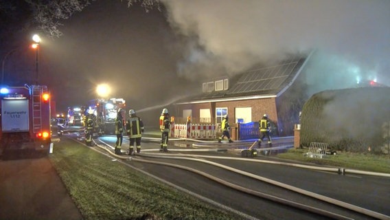 Einsatzkräfte der Feuerwehr löschen ein brennendes Wohnhaus in Haren. © Nord-West-Media TV 