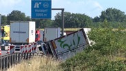 Ein umgekippter Lkw liegt in einem Straßengraben neben der A1. © Nord-West-Media TV 