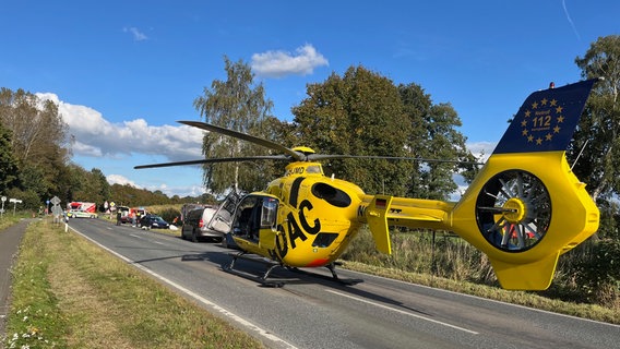 Ein Rettungshubschrauber steht auf einer Straße, vor ihm befindet sich eine Unfallstelle. © Feuerwehr Lemförde Foto: Dr. Michael Schütz