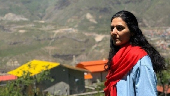 Golrokh Iraee trägt Schal und Bluse und blickt in die Landschaft, im Hintergrund sind Berge zu sehen. © Hawar.help Foto: privat