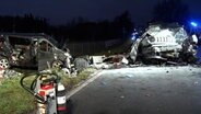 Ein Kleinbus und ein Pkw stehen völlig zerstört nach einem Unfall an einer Straße nahe Meppen. © Nord-West-Media TV 