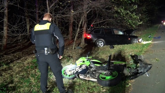 Ein Polizist steht vor einem Motorrad und einem Auto nach einem Unfall auf der B70 bei Meppen © Nord-West-Media TV 