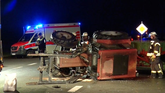 Rettungskräfte neben einem umgestürzten Traktor nach einem Unfall in Neuenkirchen © Nord-West-Media TV 