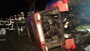 Rettungskräfte neben einem umgestürzten Traktor nach einem Unfall in Neuenkirchen © Nord-West-Media TV 