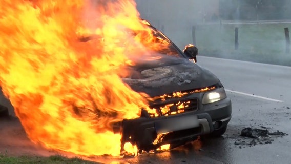 EInsatzkräfte der Feuerwehr löschen einen brennenden Pkw. © Nord-West-Media TV 