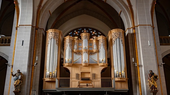 Die Orgel  in der Kirche St. Johann in Osnabrück mit Kirchenfenstern im Hintergrund. Rechts und links der Orgel hängen Figuren. © Bistum Osnabrück Foto: Oliver Pracht