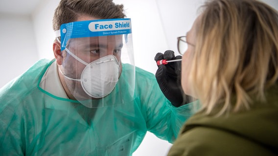 Nordhorn: A smear for a PCR test is taken by an employee in the Corona test center.  © dpa-Bildfunk Photo: Sina Schuldt