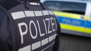 Das Logo der Polizei auf der Dienstkleidung eines Polizisten. © picture alliance Foto: Bernd Weißbrod