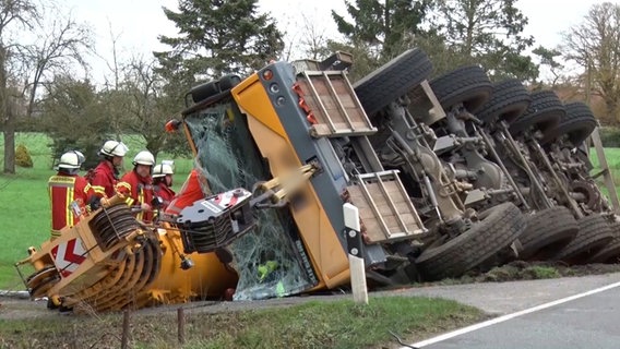 Ein umgekippter Kranwagen liegt in Quakenbrück neben einer Straße. © Nord-West-Media TV 