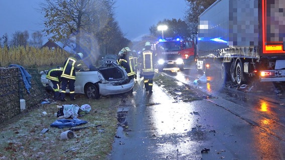 Einsatzkräfte stehen in Surwold an einer Unfallstelle neben einem Pkw und einem Lkw. © Nord-West-Media TV 