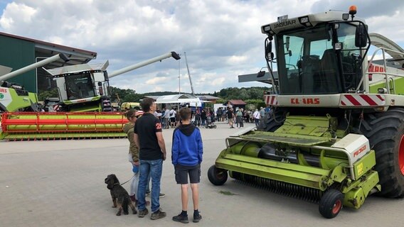 Menschen besuchen beim Tag des offenen Hofes den Agrarservice Lingemann in Osnabrück und schauen sich Landmaschinen an. © NDR Foto: Göran Theo Ladewig