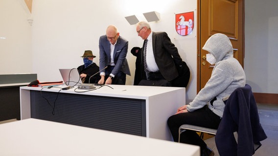 Thorsten Diekmeyer (2.v.l) und Markus Seiters (2.v.r), die Verteidiger der Angeklagten, stehen neben ihren Mandanten in einem Saal vom Amtsgericht. © Friso Gentsch/dpa Foto: Friso Gentsch