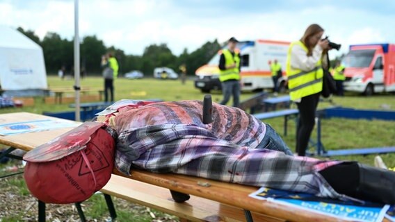 Ein stark verwundeter Dummy liegt auf einer Bank. © dpa-Bildfunk Foto: Lars Penning/dpa