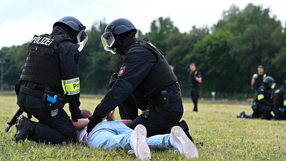 Polizisten nehmen Menschen fest. © dpa-Bildfunk Foto: Lars Penning/dpa
