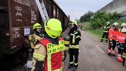 Bei einer Übung im Osnabrücker Hafen stehen zahlreiche Rettungskräfte an einem Waggon. © TeleNewsNetwork 