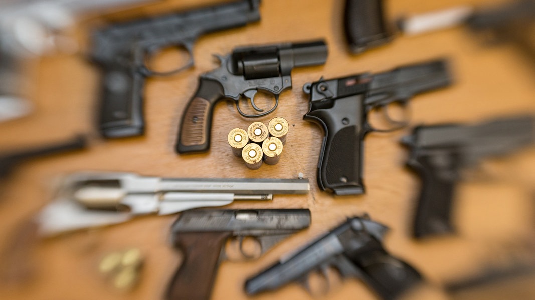 Kurzwaffen (Pistolen und Revolver) und Munition liegen auf einem Tisch in der gesicherten Asservatenkammer der Waffenbehörde des Landkreises Osnabrück.