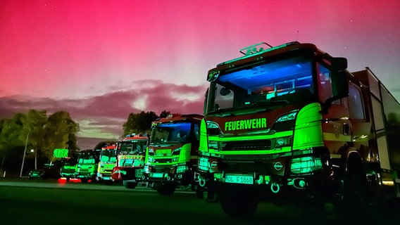 Polarlichter leuchten am Himmel hinter Einsatzfahrzeugen der Feuerwehr Wildeshausen. © Pressestelle Kreisfeuerwehr Oldenburg 