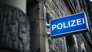 An einer Hausfassade hängt ein Leuchtschild mit der Aufschrift Polizei. © NDR Foto: Julius Matuschik