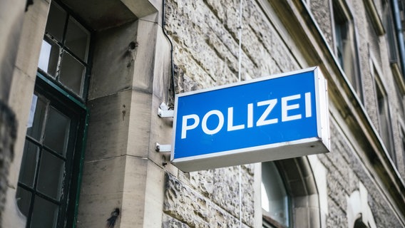 An einer Hausfassade hängt ein Leuchtschild mit der Aufschrift Polizei. © NDR Foto: Julius Matuschik