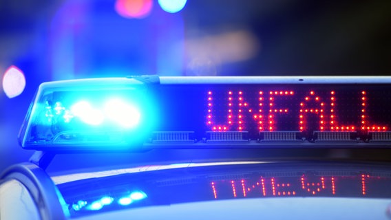 Ein Polizeiwagen mit Blaulicht warnt mit einer Leuchtschrift auf dem Dach vor einem Unfall. © dpa Bildfunk Foto: Stefan Puchner/dpa