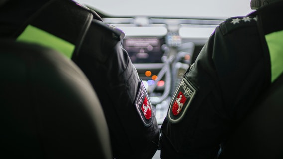 Das niedersächsische Wappen auf der Uniform von zwei Polizeibeamten. © NDR Foto: Julius Matuschik