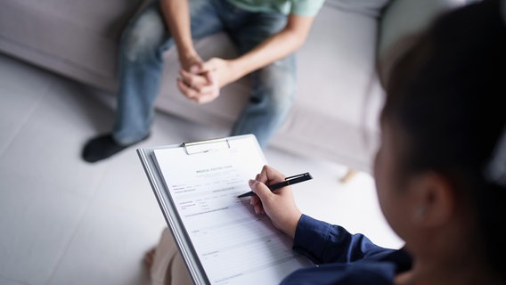 Eine Person erfasst während einer Psychotherapie die Daten eines Patienten. © picture alliance / Zoonar | Sirijit Jongcharoenkulchai Foto: Sirijit Jongcharoenkulchai