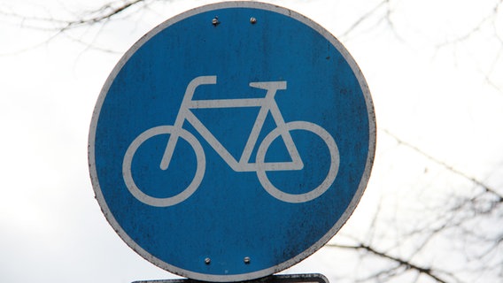 Ein blaues Schild mit einem Fahrrad kennzeichnet den Fahrradweg. © NDR Foto: Eric Klitzke